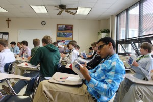 A freshman English class taught by Ms. Missy Clay looks through copies of "Catch 22," donated by Mrs. Dentinger to celebrate World Book Day.